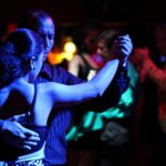 couple qui danse le tango argentin avec des gens en arrière plan