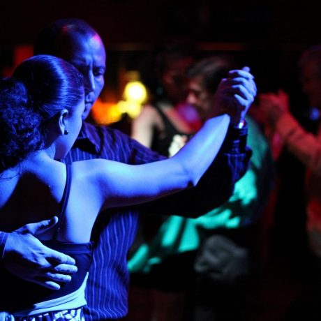 couple qui danse le tango argentin avec des gens en arrière plan
